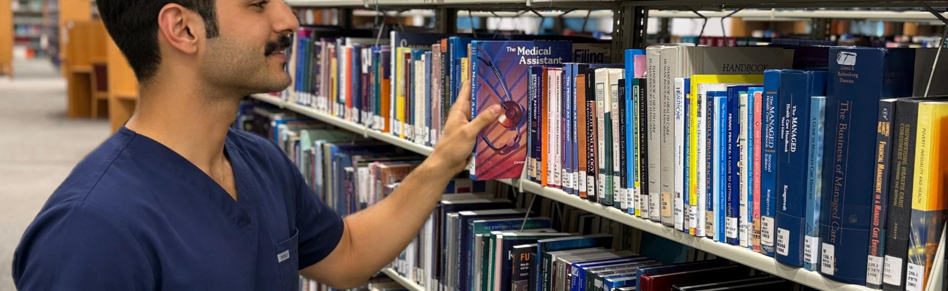 Medical student browsing books at the Health Sciences Center Library